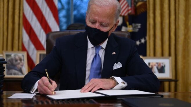 Biden-signing-papers-at-his-desk