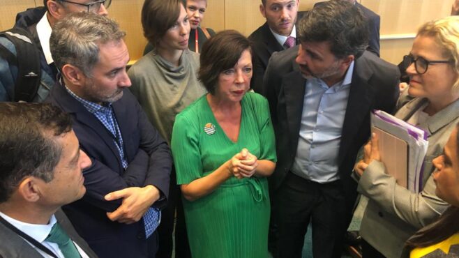 Theresa-Griffin-in-green-dress-at-centre-of-huddle