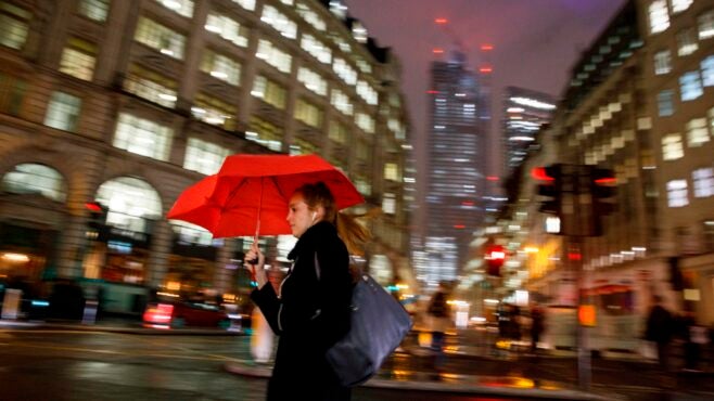 woman-with-red-umbrella-against-blurred-backdrop-City-of-London-in-the-rain