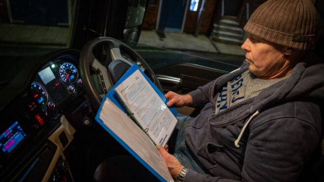 driver-in-car-looking-over-paperwork