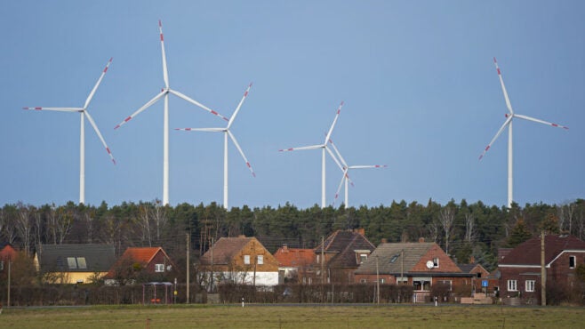 wind-turbines-behind-field-and-houses