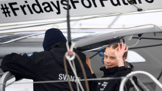 Swedish climate activist Greta Thunberg waves