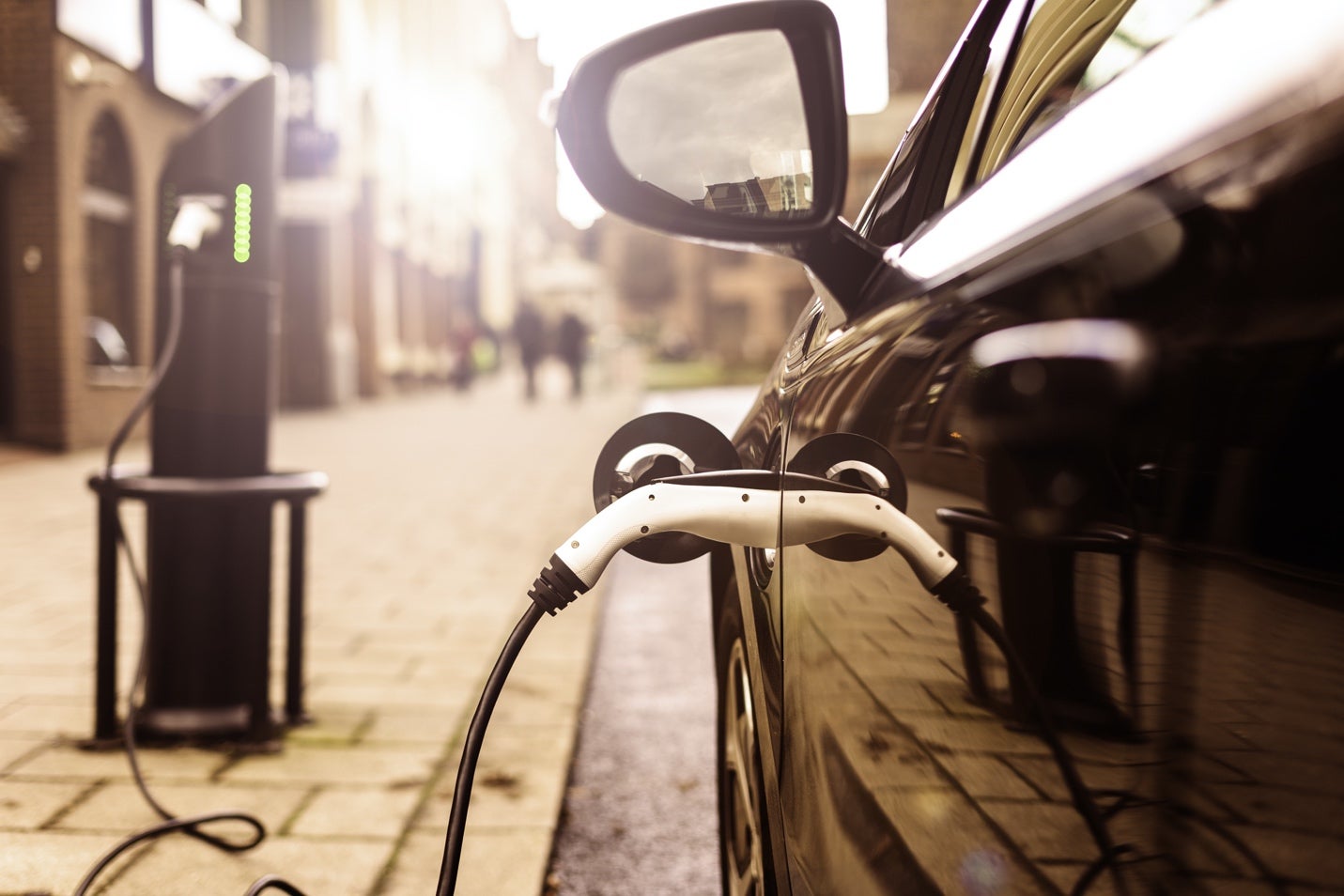 An electric vehicle charging on a street.