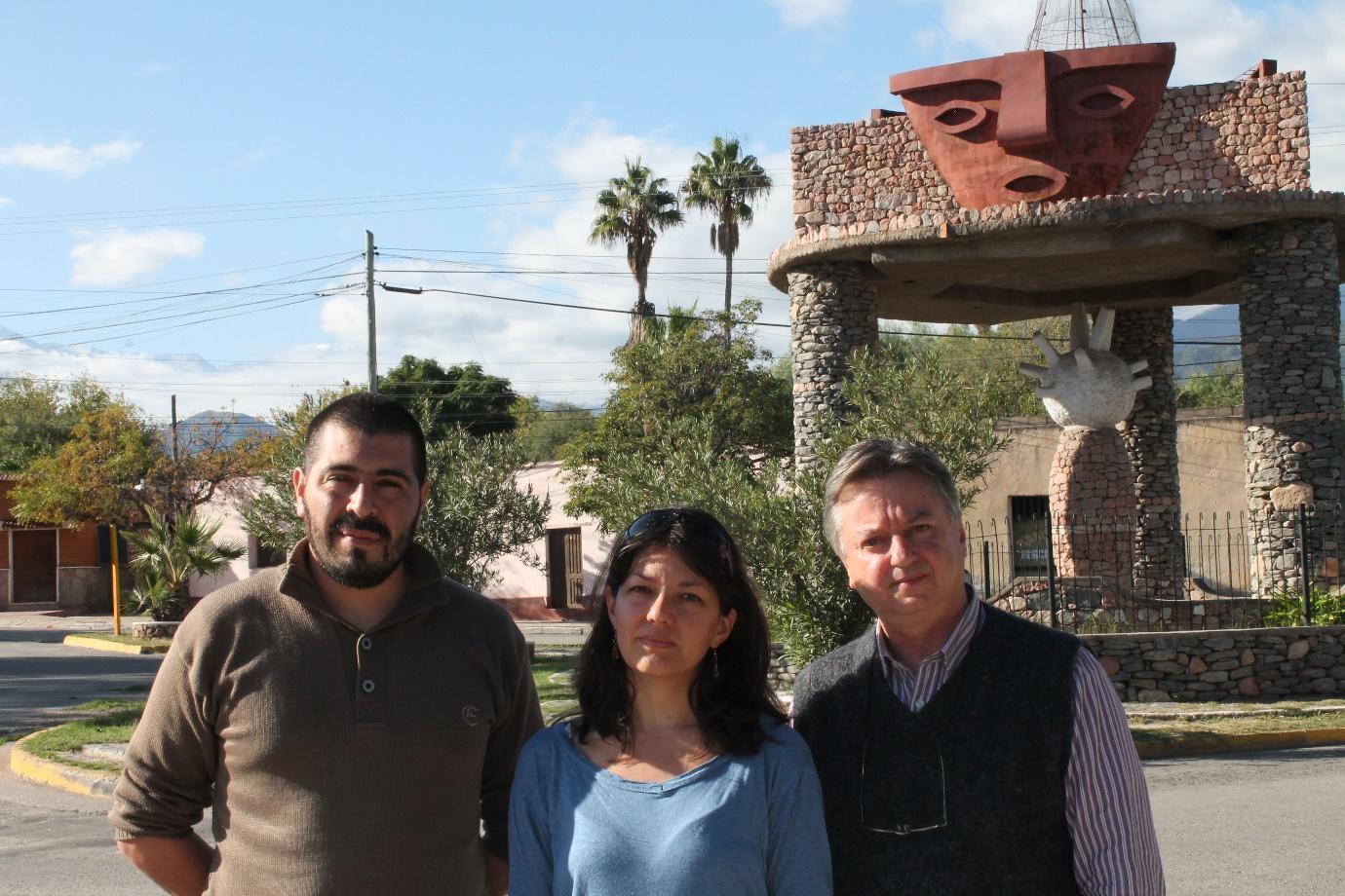 A group of people standing in front of a stone structure

Description automatically generated